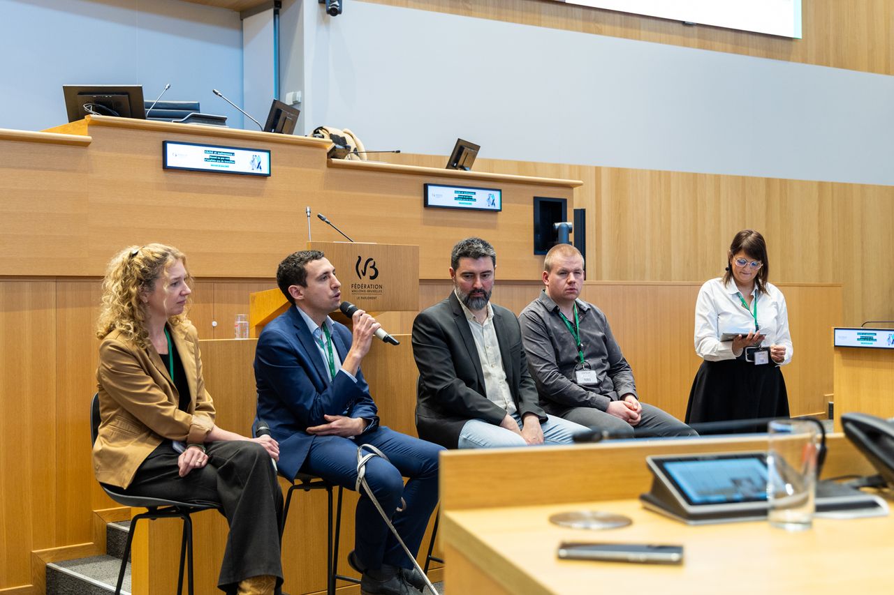 Les intervenants sont au centre de l'hémicycle et échangent avec le public de la conférence