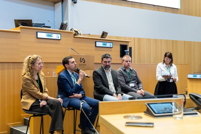 Les intervenants sont au centre de l'hémicycle et échangent avec le public de la conférence